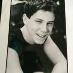 John Gallagher Jr. Instagram – I’m taking a cue from the GOAT @msmelanielynskey here. As you can see from this questionable old headshot (why the sleeveless tee?!) I’ve been working as an actor for a while now. I’m not exactly sure when I got my @sagaftra card but I was still a teenager so it must’ve been around the time this picture was taken. I’ve been extremely fortunate to work fairly steadily throughout my 23 years in this volatile and ever evolving industry. Work has been waining for me in the last few years though as it has been for many performers. A combination of factors including the pandemic, slowing momentum, plain old aging, changing trends, a pickiness about what roles I accept that I’ve been privileged enough to try and maintain and now this necessary but disruptive reckoning with the forces and factors of corporate greed that have slowly been eroding protections for the workers over the last decade. With so much at stake, not just for me but the entire profession, I feel the vital need to stand strong and proud in solidarity during this strike with my fellow actors/writers/creators and human beings who only wish to be paid fairly for their work and not be replaced by AI. It’s not an unreasonable ask. As the late, great Richard Manuel once sung, “I’m a union man now, all the way.” ✊🏻