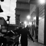 Lado Kvataniya Instagram - Пока мы выводили проекцию на высотку, за нашими спинами происходило задержание группы лиц неопределённой национальности. Сотрудники уверено вязали молодых людей, положив их лицами на капот. Нас они старательно не замечали, а мы взаимно игнорировали их в ответ. Было у нас на все не больше часа, но как это обычно случается вся техника магическим образом отказывалась работать. Проектор весит под 100 килограмм, а нам его надо повернуть набок, чтобы вывести проекцию в нужном положении. Потом он и вовсе перестал включаться. Коптер глушили фсо-шные вышки. Он взлетал на 10 метров и тут же терял управление. Стали поступать предложения сделать проекцию на CG, но я отказывался верить. Все должно быть по-настоящему! Когда еще нам выпадет возможность вывести гигантские лица поэтов на сталинскую высотку? В самый последний момент, когда времени практически не оставалось, нам удалось снять запланированые кадры. Каждый раз, когда я проезжаю мимо этой величественной постройки, то на фасаде здания я “вижу” нашу проекцию. Виртуальная подпись, которую мы оставили всей нашей командой • Backstage from @klepnev | #noizemc #почитайстарших #hypeproduction