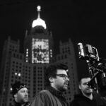 Lado Kvataniya Instagram - Пока мы выводили проекцию на высотку, за нашими спинами происходило задержание группы лиц неопределённой национальности. Сотрудники уверено вязали молодых людей, положив их лицами на капот. Нас они старательно не замечали, а мы взаимно игнорировали их в ответ. Было у нас на все не больше часа, но как это обычно случается вся техника магическим образом отказывалась работать. Проектор весит под 100 килограмм, а нам его надо повернуть набок, чтобы вывести проекцию в нужном положении. Потом он и вовсе перестал включаться. Коптер глушили фсо-шные вышки. Он взлетал на 10 метров и тут же терял управление. Стали поступать предложения сделать проекцию на CG, но я отказывался верить. Все должно быть по-настоящему! Когда еще нам выпадет возможность вывести гигантские лица поэтов на сталинскую высотку? В самый последний момент, когда времени практически не оставалось, нам удалось снять запланированые кадры. Каждый раз, когда я проезжаю мимо этой величественной постройки, то на фасаде здания я “вижу” нашу проекцию. Виртуальная подпись, которую мы оставили всей нашей командой • Backstage from @klepnev | #noizemc #почитайстарших #hypeproduction