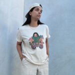 Lilly Singh Instagram - Maybe if I just play with my necklace a little… okay good, yes. And then maybe look away into space as if I’m pondering. Nailed it. One hand in pocket. Good, good. Adjust the hat a bit perhaps? Is this good? Wait, let me lean in a tad too on the side that hides my pimple. Perfffff. Boom. Candid. Natural. Sorry, just love my fit too much today. Monochromatic cream? It’s giving, “I carry a Tide pen in my pocket.” Ufffff. Grab yourself a “Books Over Bakwaas” t-shirt or sweater. For a limited time. Link in bio. 🔗 20% of proceeds go to @unicornisland Fund to help girls and women in India live life to their fullest potential (including literacy skills!) We love a full circle fashion-giveback moment. #GivingTuesday #LillysLibrary #HoliChic