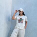 Lilly Singh Instagram - Maybe if I just play with my necklace a little… okay good, yes. And then maybe look away into space as if I’m pondering. Nailed it. One hand in pocket. Good, good. Adjust the hat a bit perhaps? Is this good? Wait, let me lean in a tad too on the side that hides my pimple. Perfffff. Boom. Candid. Natural. Sorry, just love my fit too much today. Monochromatic cream? It’s giving, “I carry a Tide pen in my pocket.” Ufffff. Grab yourself a “Books Over Bakwaas” t-shirt or sweater. For a limited time. Link in bio. 🔗 20% of proceeds go to @unicornisland Fund to help girls and women in India live life to their fullest potential (including literacy skills!) We love a full circle fashion-giveback moment. #GivingTuesday #LillysLibrary #HoliChic