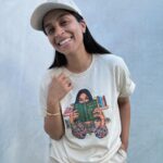Lilly Singh Instagram - Maybe if I just play with my necklace a little… okay good, yes. And then maybe look away into space as if I’m pondering. Nailed it. One hand in pocket. Good, good. Adjust the hat a bit perhaps? Is this good? Wait, let me lean in a tad too on the side that hides my pimple. Perfffff. Boom. Candid. Natural. Sorry, just love my fit too much today. Monochromatic cream? It’s giving, “I carry a Tide pen in my pocket.” Ufffff. Grab yourself a “Books Over Bakwaas” t-shirt or sweater. For a limited time. Link in bio. 🔗 20% of proceeds go to @unicornisland Fund to help girls and women in India live life to their fullest potential (including literacy skills!) We love a full circle fashion-giveback moment. #GivingTuesday #LillysLibrary #HoliChic