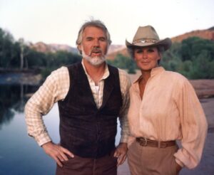 Linda Evans Instagram - I absolutely loved working with Kenny Rogers – it was memorable for a million reasons. He was one of the great ones – kind, thoughtful, dear… the best of men. 
Many of you know that I love pizza so much, that if you wake me up in the middle of the night and ask me if I’d like a slice, I’ll say YES. Kenny used to have it delivered to me while we filmed The Gambler. 
When I “sang” with Kenny, he assured me that no matter how I sounded, they could fix me in the studio. I trusted him completely. He was such an incredible singer and songwriter. But the truth be known, even though I would be dubbed, I still had to perform the song. I’ll never forget those moments as I belted out, way off-key, while Kenny stayed in character, holding a straight face, and all I could feel was his love. 
He was a remarkably good man who brought music into all our lives, and his unforgettable voice and beautiful heart will live on in mine. 💛🎶🌟