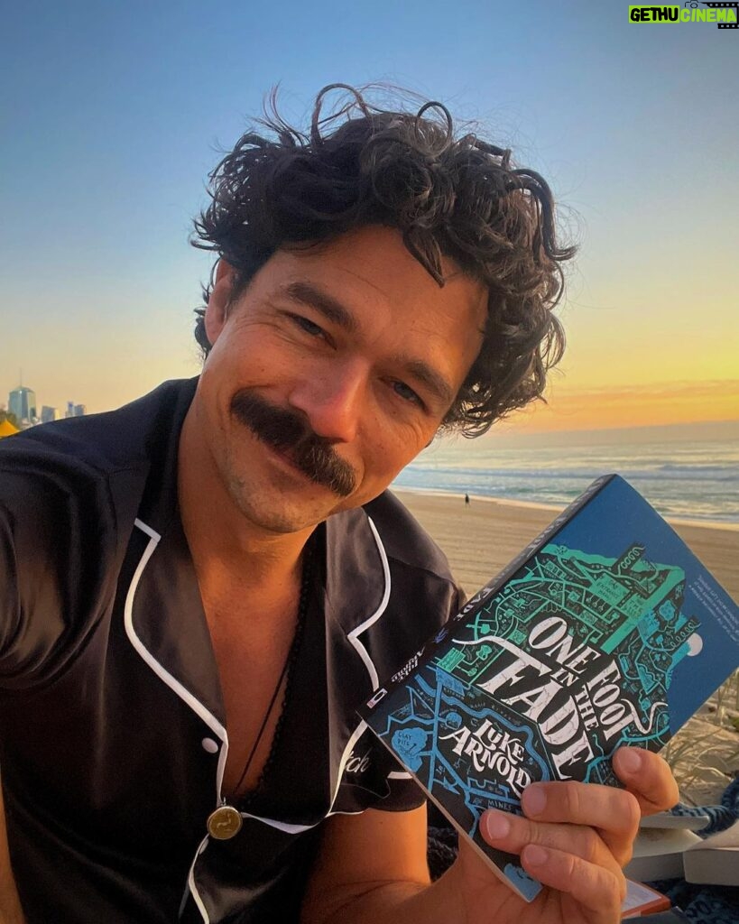 Luke Arnold Instagram - Up at sunrise to read books on the beach in my pjs. If you haven’t jumped over to my Tiktok yet, what are you doing? The First Page Pajama Party has hit the road 📚 (Outfit courtesy of @midnightmischiefsleepwear)