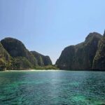 Mónica Jardim Instagram - Já lá vão 24 anos desde que o filme "A Praia" fez de Maya Bay uma das praias mais visitadas na Tailândia. Recebeu tanto turismo desde então, que nos últimos 4 anos esteve fechada por causa dos danos ambientais. Conseguiu ganhar novamente vida com a recuperação da sua fauna e flora. Os tubarões voltaram, os corais estão a crescer e a água está novamente limpa. Com esta reabertura em Outubro de 2023, há novas regras: os barcos não podem atracar junto à praia, não é permitido tomar banho e só entra um número reduzido de visitantes por dia. Eu acrescentava mais uma: punha o DiCaprio a tirar selfies 😜 #mayabay #thebeach #phiphiisland #thailand🇹🇭 @turismo_da_tailandia Maya Bay, Phi Phi Island, Thailand