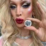 Ma’Ma Queen Instagram – Dragqueens love coins! Helemaal deze bijzondere munt. Dit is namelijk de herdenkingsmunt dat het @cocnld 50 jaar geleden erkenning kreeg. Daarom heeft @royaldutchmint deze speciale limited edition munt geslagen. 
Het coc is een belangenorganisatie die zich al ruim 60 jaar inzet voor acceptatie en emancipatie van de lgbtqia+ communitie. Waarvan dus 50 jaar als door het koningshuis erkend. 
Mijn eerste queer avond in Doetinchem, waar ik ben geboren en opgegroeid, was een COC avond in een buurthuis. Hoe meer ik mn queer identiteit heb ontdekt des te vaker ik deze organisatie tegen kwam. We hopen natuurlijk dat deze organisatie op een gegeven moment niet meer nodig is omdat we allemaal veilig ons zelf kunnen zijn. Maar het tegenover gestelde is helaas waar. Daarom zijn organisaties zoals het COC ontzettend belangrijk. 
Ik dacht voor deze gelegenheid ga ik lekker de straat op, om te laten zien dat ik me niet uit het veld laat slaan en mn plek in de maatschappij claim, zichtbaar ben en mezelf ben waar ik ook kom! 
@cocnld bedankt voor jullie kracht, doorzettingsvermogen en inspiratie. En natuurlijk bedankt dat ik deze bijzondere munt heb mogen ontvangen! 
Je kan je eigen munt bestellen op www.knm.nl/coc #royaldutchmint #munt #coin #coc