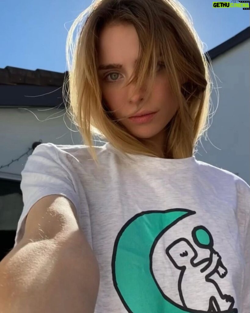 Maddie Phillips Instagram - I have been secretly designing my own merch line and today i set her free !!! the seeds for this expansion were planted as an 11yr old when i would design ~soft angst funny sk8er grl~ clothes (and took it VERY seriously lol) under the pseudo name Anarkid (which would then become my personal company name). 16 years later i found myself for the first time in years, (despite many wonderful new blessings in my life) not being able to feel my feet on the ground & with no clear vision. I started experiencing panic attacks like I’d never known until I one day when my body was simply too EXHAUSTED to freak out again, I had the sudden awareness that i was aching to create tangible expression and literally the day after I articulated in my mind that I would honor my desires and somehow delve into that realm, I received a dm from Frank @sunshineshop.la asking if I had ever thought about creating my own merch line. lmao :’) indeed I had. 🌙 I drew the little mirror holding moon-being 6 years ago during a significant era of reflection and it’s been on my bedroom wall ever since. i am no illustrator however !!! the fairies/dancing muses are the works of two talented artists who were able to conjure up my creative visions. i will be so tickled to see what resonates with you all !! but i must say … hehe… i am so utterly fulfilled by this entire experience already and am truly releasing this with such joyful detachment because; the best thing about it all is the reminder that when introspection & participation start to reach for each other’s hands and begin to dance, doors are revealed and your expanded selves greet you with beaming faces and open arms and exclaim “WE FUCKING KNEW IT !!! WELCOME HOME BABY!!!!!” Thank you Frank my friend @sunshineshop.la for opening the door 💛 🪞🪄🌙 link in bio 🪞🪄🌙 artist collaborators !!! @alsor.studio (OWTF) @jhen.ai ( 🧚 ) 22222
