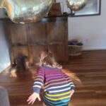 Mary Katharine Ham Instagram - This gal turned two! For those keeping count, that means we had two under two… for 9.5 months. And we’re still standing! A lot of the credit for that goes to Holly, who much like her father, has a GIANT personality and also loves a schedule. That means she sleeps. Hallelujah, can that girl sleep, from 6pm-7am, in the same room as her brother. When we say “bedtime for baby?” after two episodes of “Bluey,” our girl marches herself up the stairs to get her zzzzs. “Bye, guys! Bye, guys! Bye, Guggy!” (this is either doggie or Garnet, we’re not sure which) She is a woman of few words. She says “Dad” constantly, “wow” and “Scout” and “stop” and “don’t,” usually to her bro. She has a long-running joke where I ask her to say “Mama,” and she mouths it without actually saying anything and then laughs because, let’s face it, that’s funny. But she resorts to “Mama” when she’s very sad, which isn’t often. She is good-natured and very physical. The other day, I told her to say “please,” and I would lift her over the couch, and she was stubborn about “please” and simply hoisted herself over the couch with a ridiculous display of brute upper body strength. She is newly into books, but her brute strength makes her the first kid I’ve ever had capable of destroying board books. She might be the most problem-solving kid I’ve had. She untied, collapsed and removed the tent pole from her little play tent in the living room while I wasn’t looking the other day, then uncollapsed it to hold up in front of me. (Meanwhile, her brother is already saying “bottle” in an effort to defend himself against her when she steals his bottle, which is often). Watching her play is a bit like watching the velociraptors test the fences. “Clever girl.” She loves to clean (also gets that from Dad), brings her own diapers for diaper changes and throws the dirty ones away. She’s just started doing “big hugs” and will hug you and sigh and pat you on the back. Sings along with “Daniel Tiger” and loves cheese, ham, and anything I’m eating. She has made a lot of our lives possible the last 9 months by just being her and, boy, do we love her! Can’t wait to see her grow!