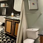 Mary Katharine Ham Instagram - Operation give my weird guest bathroom with UPHOLSTERED FABRIC MOLDING a very dramatic makeover while my husband was out of town because he does not mind my results, but does not enjoy my chaos. It’s a long name for an op. Five days, four kids, dye the grout, paint the tile, refinish the vanity, hang a new mirror, add knick-knacks, call in @lyndseyfifield to help me clean and hold the baby. Steve arrives in time to install my new light fixture. Ta-dahhhh! Did I mention I was tempted to paint everything in my house black? #diy #paintitblack #paintedtiles Oh, and I did keep that weirdly placed medicine cabinet bc Steve loves practical storage and it was too short a timeline to rip it out, do drywall repair, and paint over it. All the products are in my Substack write-up in my bio!