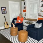 Meaghan B. Murphy Instagram - 🚨NEW 🏡 PROJECT🚨 Sometimes you need to fix 🛠️something that isn't broken just because it no longer works FOR YOU. That was the case with this sitting room. I loved the original design, but in 5 years NO ONE actually EVER sat in the sitting room. So, here's what we did to change that because with 3 kids and a dog we need to eek out every ounce of living space in our home: 🪑 First up, more functional furniture. We said goodbye to my oversized family heirloom chair (luckily Nana was excited to put it in her bedroom) and banished the stuffy (but pretty!) bench to my office. I saw these navy @potterybarn swivel chairs at my girlfriend's house and ordered them immediately. I have grown to appreciate the entertainment value of a swivel. Then I was at a loss, so I called in @thehavenly for a little design hand-holding. Havenly helped me land on this @arhaus table + ottomans & approved my striped @potterybarnkids rug choice (I needed the validation). WOWZA! Suddenly this space became a cozy spot for morning ☕️ after-dinner 🫖 and unwinding w/ a 🍷 where I can stare at my guitar 🎸 and the lyrics to Blackbird 🐦‍⬛ and manifest playing it someday. I think lessons would help. LOL The other big change here was brightening up the bookcases with a fresh coat of white. 🎨 I think it makes my book 📕 ⚡️& beloved knickknacks pop. Leave it to @shadyladycolors and @amazingpaintingnj to make the magic 🪄 happen. We also added battery-operated book lights from @lampsplus that make me endlessly happy at night. 💡 Finally, @ellaallure killed it with the Dempsey-friendly performance fabric cushion in just the right orange-y shade + fun patterned pillows. What do you think? I love that my friend @sarapeterson_thenext who founded HGTV mag calls small projects like this a "Twirl Up." I'm working on a whole issue of @womansdaymag devoted to mini makeovers like this. If you have a project to share, DM or email me! #makeover #homeproject #homerenovation #homerenovations #homeprojects #painting #bookshelves #arhaus Home Sweet Home