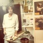 Michael Imperioli Instagram - Anthony Bourdain in the kitchen and Harvey Keitel in Taxi Driver over Tony’s left shoulder. I love this photo as it includes two people I will always hold in very high esteem. After I read Kitchen Confidential I sought Tony out in hopes of making it into a series or a film. It was difficult but I managed to track him down. I can be relentless when I am on a mission, and lo and behold he invited me to lunch at Le Bernadin, his pal Eric Ripert’s (a dharma brother) stellar restaurant in Midtown. When I arrived, Tony was waiting and watching stealthily a few doors down, leaning against the wall, smoking a cigarette. We walked in together and Eric fed us a seven course lunch with different wines for every dish…it was epic and revelatory. Tony and I connected right away on music, books, movies and NYC lore. Finally he asked why I reached out. I told him that I had worked in nyc restaurants for 9 years, as a prep cook, line cook, bus boy, food runner, waiter, bartender and deli counter man. I said that his book was so honest, accurate, articulate and entertaining that I thought it should be a film or a series. But sadly I was too late. He told me he had already sold it to Fox who fucked it up royally. It died on the TV trash heap having been fed through the Hollywood meat grinder. But the five hour lunch with Tony was unforgettable and well worth whatever effort I made to find him. He was a gem. @friendsofanthonybourdain #anthonybourdain #ericripert #lebernardin @ericripert @lebernardinny @anthonybourdain