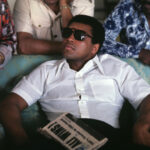 Muhammad Ali Instagram - Muhammad Ali during an interview with the press after winning his fight vs Joe Frazier at Hilton Hotel. Ali is holding a newspaper with a headline that says “ALI WINS.”⁣ ⁣ Manila, Philippines – October 1975.⁣ ⁣ 📸: @neilleiferphotography⁣ ⁣ ⁣ #MuhammadAli #Icon #ThrillainManila #MuhammadAlivsJoeFrazier #Boxing #Legendary #GOAT #Champion