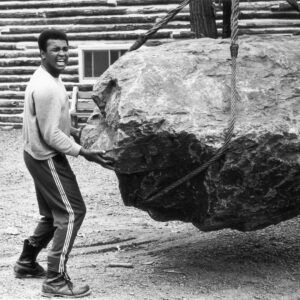 Muhammad Ali Instagram - Muhammad Ali pushing a boulder during a photo shoot at his training camp cabin in Deer Lake, PA.⁣
⁣
📸: @neilleiferphotography⁣
⁣
 ⁣
#MuhammadAli #Icon #DeerLake #Photoshoot #TrainingCamp #NeilLeifer