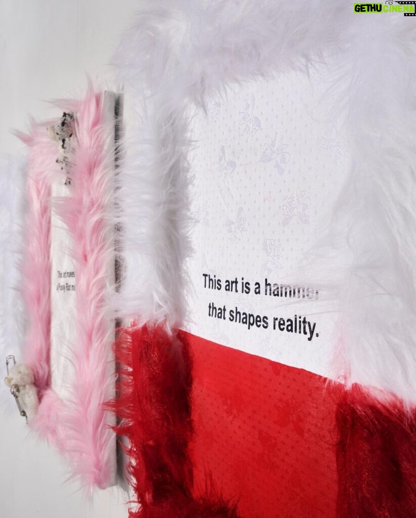 Nadezhda Tolokonnikova Instagram - This art is a hammer that shapes reality (series) 🩸🔨 2023 The text is printed on fabric. I use textile because traditionally it was labeled as low art/crafts, female work - and because I was forced to work with textile in my penal colony. The fabric is stapled to canvas, and pink and white fur is stapled to canvas as well. I use pins, needles, and parts of the sewing machine in this series, finally fulfilling my prison dreams about getting new sets of needles - now I'm a free person and can just order them online, it was a big pleasure ordering them! "We can't give you new needles and parts to fix your machine, did you forget where you are? You're in RUSSIA" - I was told in prison when I asked to fix my equipment. Splashes of acrylic paint on the fabric are reminiscent of my blood getting spilled on police and military uniforms that I was sewing in prison, injured by old and outdated equipment. For more solid red paint coverage - like in "This art screams in pain" piece - I used red spray paint, a tool that was widely used in my activist anarchist youth. Teddy bears are penetrated with needles like my fingers used to be when I was sewing in prison, teddy bears are covered in Putin's Ashes - I saved a bucket of ashes after the performance in August 2022 and now use it as art material. I combine cute and dangerous, playful and serious in this series, just like we did in our name, Pussy Riot. The harsh statements are combined with plush toys and faux fur 💣🐁 Once Marina Abramovic asked me why I like baby pink so much, she hates baby pink. I said that I want to look cute when cops are arresting me, I want them to look stupid. She said, ok, you're the only person I can accept wearing baby pink and hello kitty backpacks.