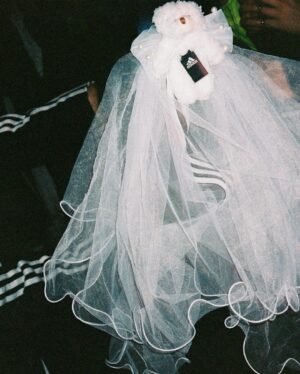 Nadezhda Tolokonnikova Instagram - 💍🔪🫀 american boy уеду с тобой

@voguemagazine 📝: Sewing used to be a source of trauma for Pussy Riot’s Nadya Tolokonnikova, who was forced to stitch military and police uniforms while in a Russian penal colony. 

But she decided to reclaim the activity when she sewed Adidas stripes onto her now-husband John Caldwell’s suit jacket, for their wedding on 12 January. “Now I feel like I can sew again without being necessarily connected to the traumatic experience,” she says. “It broke the chain of trauma.”

She wanted to create contrast between the “cute” side of her personality with the “gopnik” side. Tolokonnikova, who is vegan, juxtaposed her sweet look with an oversized black faux-leather Adidas jacket. She also wore a pair of velvet Doc Martens, though she changed into slides from—you guessed it—Adidas during the party. 

Tolokonnikova also included the Orthodox cross in her ceremony: on a necklace, garter belt, and even the vegan Napoleon cake covered in black icing, which she baked herself. “I’m almost trying to steal [the symbol] from the Orthodox Christianity, honestly, because they stole two years of my life,” she says. “I was accused—besides going against Putin—of religious hatred, which I didn’t have. But they still accused me of it. So I was like, Well, I’m just going to be using your symbol and reclaim it as my own.” She and Caldwell were married by Father Nathan Monk, who was excommunicated from the Russian Orthodox church for his support of the LGBTQ+ community, underneath a giant neon Orthodox cross. 

Photos: @marysergeevnaa 
Husbando: @vegsurfer 
Text: @hannahjacksuhn