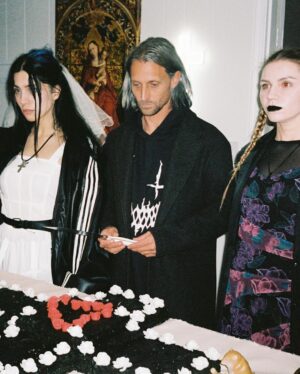 Nadezhda Tolokonnikova Instagram - 💍🔪🫀 american boy уеду с тобой

@voguemagazine 📝: Sewing used to be a source of trauma for Pussy Riot’s Nadya Tolokonnikova, who was forced to stitch military and police uniforms while in a Russian penal colony. 

But she decided to reclaim the activity when she sewed Adidas stripes onto her now-husband John Caldwell’s suit jacket, for their wedding on 12 January. “Now I feel like I can sew again without being necessarily connected to the traumatic experience,” she says. “It broke the chain of trauma.”

She wanted to create contrast between the “cute” side of her personality with the “gopnik” side. Tolokonnikova, who is vegan, juxtaposed her sweet look with an oversized black faux-leather Adidas jacket. She also wore a pair of velvet Doc Martens, though she changed into slides from—you guessed it—Adidas during the party. 

Tolokonnikova also included the Orthodox cross in her ceremony: on a necklace, garter belt, and even the vegan Napoleon cake covered in black icing, which she baked herself. “I’m almost trying to steal [the symbol] from the Orthodox Christianity, honestly, because they stole two years of my life,” she says. “I was accused—besides going against Putin—of religious hatred, which I didn’t have. But they still accused me of it. So I was like, Well, I’m just going to be using your symbol and reclaim it as my own.” She and Caldwell were married by Father Nathan Monk, who was excommunicated from the Russian Orthodox church for his support of the LGBTQ+ community, underneath a giant neon Orthodox cross. 

Photos: @marysergeevnaa 
Husbando: @vegsurfer 
Text: @hannahjacksuhn