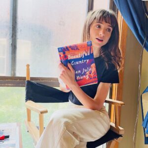 Natalia Dyer Instagram - new set, new read 🤓

excited to be one of the Book of the Month judges this september. even more excited to share my pick, Beautiful Country by @qianjuliewang. i’ve always been drawn to stories that let me explore and better understand lives that are different from mine, and her quietly powerful debut is no exception. pick it up at @bookofthemonth I know you’ll enjoy it.
