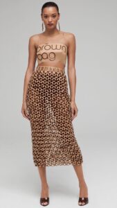 Natalia Fedner Instagram - How did I make the honeycomb paper chainmail skirt for @bloomingdales Big Brown Bag anniversary celebration? All the secrets are revealed in this video. The process starts by cutting the BBBs into 8.5 x 11” sheets, ironing them flat (yes, flashbacks to pressing paper patterns out at Parsons were had), then cutting the sheets into thousands of small strips using a hand held paper cutter (that I may have found tossed out on a street corner by my West Hollywood apartment…), and finally taping them together with little double sided tabs to create a honeycomb like pattern. I used this technique to create the skirt for the project, finishing it off with a Bloomingdales waistband (sourced from the side of the bag). The paper skirt is delicate, but because of the technique I developed for the project, it actually stretches quite a bit and allows a full range of movement! #bigbrownbag #paperart #paper #papercrafts #bloomingdales #kraftpaper #garlands #diy #paperdress