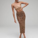Natalia Fedner Instagram - Surprise!!! When @bloomingdales reached out to me about making a dress to celebrate the 50th anniversary of the Big Brown Bag - I was immediately on board! I wanted to bring my brand’s DNA to the project, while maintaining the integrity of the iconic Big Brown Bag kraft paper aesthetic. So I created a special chainmail made from actual Bloomingdale’s Big Brown Bags. This tiny paper chainmail, like my metal designs, is entirely hand made. The process starts by cutting the BBBs into 8.5 x 11” sheets, ironing them flat (yes, flashbacks to pressing paper patterns out at Parsons were had), then cutting the sheets into thousands of small strips using a hand held paper cutter (that I may have found tossed out on a street corner by my West Hollywood apartment…), and finally taping them together with little double sided tabs to create a honeycomb like pattern. I used this technique to create the skirt for the project, finishing it off with a Bloomingdales waistband (sourced from the side of the bag). The paper skirt is delicate, but because of the technique I developed for the project, it actually stretches quite a bit and allows a full range of movement! For the top, I wanted to design something a little more clean and simple that really focused on the theme. So I opted for a 90’s style bandeau top with the famous words front and center, integrating hand straps from actual bags to create shoulder straps for the top. By incorporating a few smart darts in the front and some corset work in the back, I was able to transition a Big Brown Bag into a Small Sleek Top. The overall silhouette of the look gives a wink to the 1950s, celebrating Bloomingdales lasting impact on fashion. Swipe through for a small taste of BTS - more to come! And yes model @lamekafox IS wearing a pair of our own chain earrings! Shoutout to @riowarner and @maya_adelle - this was a true labor of love that involved thousands of little movements - little cuts, little bits of tape - and these two rockstars made sure I got the project done in time by helping prep thousands of paper tabs for me. And thank you @p810km for being our fit model 🥰 Thank you @ela.ine.k @tatootsie for bringing me on!!