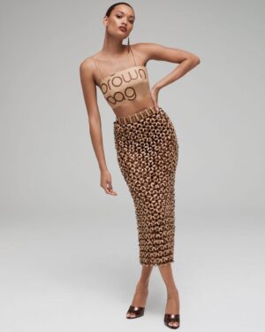 Natalia Fedner Instagram - Surprise!!! When @bloomingdales reached out to me about making a dress to celebrate the 50th anniversary of the Big Brown Bag - I was immediately on board! I wanted to bring my brand’s DNA to the project, while maintaining the integrity of the iconic Big Brown Bag kraft paper aesthetic. So I created a special chainmail made from actual Bloomingdale’s Big Brown Bags. This tiny paper chainmail, like my metal designs, is entirely hand made. The process starts by cutting the BBBs into 8.5 x 11” sheets, ironing them flat (yes, flashbacks to pressing paper patterns out at Parsons were had), then cutting the sheets into thousands of small strips using a hand held paper cutter (that I may have found tossed out on a street corner by my West Hollywood apartment…), and finally taping them together with little double sided tabs to create a honeycomb like pattern. I used this technique to create the skirt for the project, finishing it off with a Bloomingdales waistband (sourced from the side of the bag). The paper skirt is delicate, but because of the technique I developed for the project, it actually stretches quite a bit and allows a full range of movement! For the top, I wanted to design something a little more clean and simple that really focused on the theme. So I opted for a 90’s style bandeau top with the famous words front and center, integrating hand straps from actual bags to create shoulder straps for the top. By incorporating a few smart darts in the front and some corset work in the back, I was able to transition a Big Brown Bag into a Small Sleek Top. The overall silhouette of the look gives a wink to the 1950s, celebrating Bloomingdales lasting impact on fashion. Swipe through for a small taste of BTS - more to come! And yes model @lamekafox IS wearing a pair of our own chain earrings! 

Shoutout to @riowarner and @maya_adelle - this was a true labor of love that involved thousands of little movements - little cuts, little bits of tape - and these two rockstars made sure I got the project done in time by helping prep thousands of paper tabs for me. And thank you @p810km for being our fit model 🥰 Thank you @ela.ine.k @tatootsie for bringing me on!!