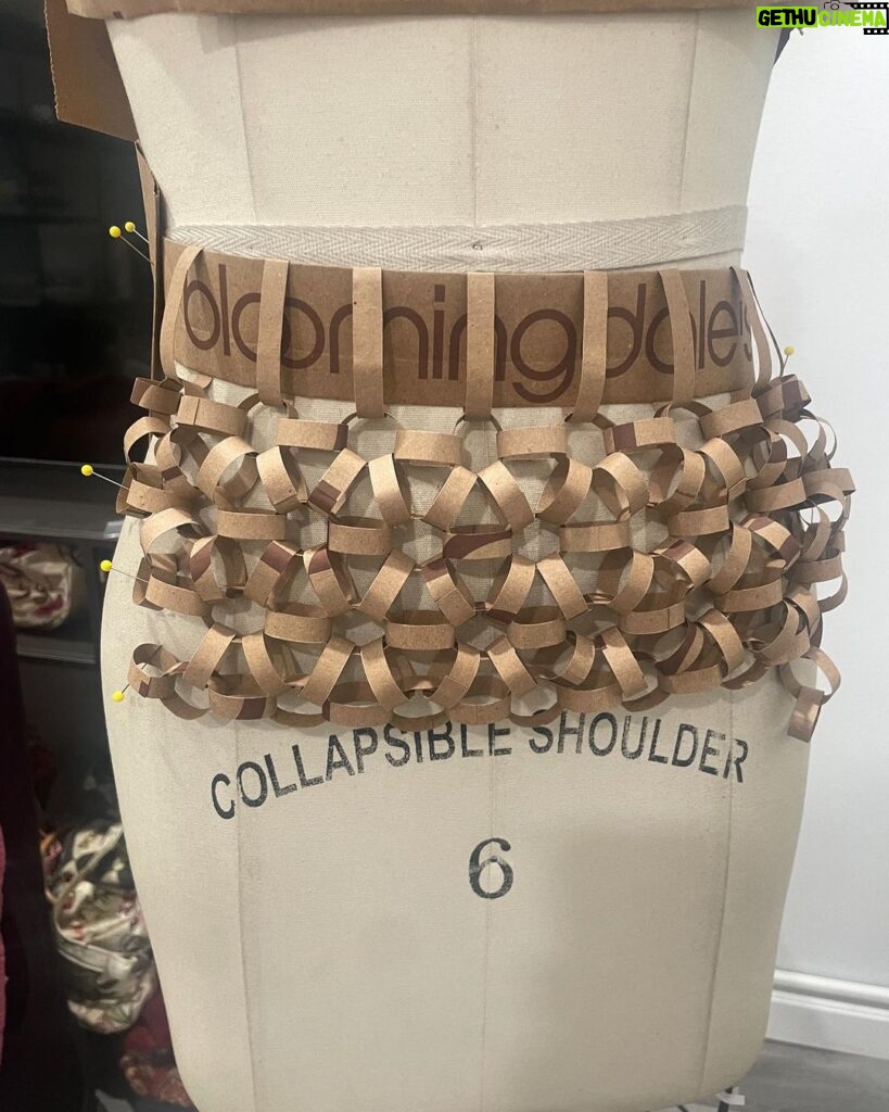 Natalia Fedner Instagram - Surprise!!! When @bloomingdales reached out to me about making a dress to celebrate the 50th anniversary of the Big Brown Bag - I was immediately on board! I wanted to bring my brand’s DNA to the project, while maintaining the integrity of the iconic Big Brown Bag kraft paper aesthetic. So I created a special chainmail made from actual Bloomingdale’s Big Brown Bags. This tiny paper chainmail, like my metal designs, is entirely hand made. The process starts by cutting the BBBs into 8.5 x 11” sheets, ironing them flat (yes, flashbacks to pressing paper patterns out at Parsons were had), then cutting the sheets into thousands of small strips using a hand held paper cutter (that I may have found tossed out on a street corner by my West Hollywood apartment…), and finally taping them together with little double sided tabs to create a honeycomb like pattern. I used this technique to create the skirt for the project, finishing it off with a Bloomingdales waistband (sourced from the side of the bag). The paper skirt is delicate, but because of the technique I developed for the project, it actually stretches quite a bit and allows a full range of movement! For the top, I wanted to design something a little more clean and simple that really focused on the theme. So I opted for a 90’s style bandeau top with the famous words front and center, integrating hand straps from actual bags to create shoulder straps for the top. By incorporating a few smart darts in the front and some corset work in the back, I was able to transition a Big Brown Bag into a Small Sleek Top. The overall silhouette of the look gives a wink to the 1950s, celebrating Bloomingdales lasting impact on fashion. Swipe through for a small taste of BTS - more to come! And yes model @lamekafox IS wearing a pair of our own chain earrings! Shoutout to @riowarner and @maya_adelle - this was a true labor of love that involved thousands of little movements - little cuts, little bits of tape - and these two rockstars made sure I got the project done in time by helping prep thousands of paper tabs for me. And thank you @p810km for being our fit model 🥰 Thank you @ela.ine.k @tatootsie for bringing me on!!