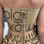 Natalia Fedner Instagram – Surprise!!! When @bloomingdales reached out to me about making a dress to celebrate the 50th anniversary of the Big Brown Bag – I was immediately on board! I wanted to bring my brand’s DNA to the project, while maintaining the integrity of the iconic Big Brown Bag kraft paper aesthetic. So I created a special chainmail made from actual Bloomingdale’s Big Brown Bags. This tiny paper chainmail, like my metal designs, is entirely hand made. The process starts by cutting the BBBs into 8.5 x 11” sheets, ironing them flat (yes, flashbacks to pressing paper patterns out at Parsons were had), then cutting the sheets into thousands of small strips using a hand held paper cutter (that I may have found tossed out on a street corner by my West Hollywood apartment…), and finally taping them together with little double sided tabs to create a honeycomb like pattern. I used this technique to create the skirt for the project, finishing it off with a Bloomingdales waistband (sourced from the side of the bag). The paper skirt is delicate, but because of the technique I developed for the project, it actually stretches quite a bit and allows a full range of movement! For the top, I wanted to design something a little more clean and simple that really focused on the theme. So I opted for a 90’s style bandeau top with the famous words front and center, integrating hand straps from actual bags to create shoulder straps for the top. By incorporating a few smart darts in the front and some corset work in the back, I was able to transition a Big Brown Bag into a Small Sleek Top. The overall silhouette of the look gives a wink to the 1950s, celebrating Bloomingdales lasting impact on fashion. Swipe through for a small taste of BTS – more to come! And yes model @lamekafox IS wearing a pair of our own chain earrings! 

Shoutout to @riowarner and @maya_adelle – this was a true labor of love that involved thousands of little movements – little cuts, little bits of tape – and these two rockstars made sure I got the project done in time by helping prep thousands of paper tabs for me. And thank you @p810km for being our fit model 🥰 Thank you @ela.ine.k @tatootsie for bringing me on!!