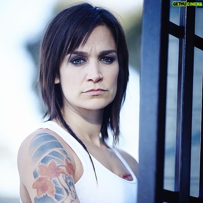 Nicole da Silva Instagram - What does this image of Franky have to do with #afghanistan🇦🇫 ? There’s news to come. In the meantime, head to the link in my bio to find out how you can help Afghan women and girls 💥 @unwomenaust 📸 @benkingphotographer Image Description: Nicole da Silva as Franky Doyle stands in front of prison bars with short cropped hair, rats tail and arm tattoo. Naarm