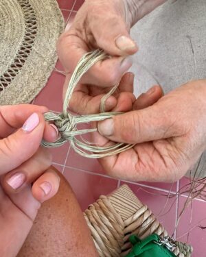 Norah Casey Instagram - As the temperature hit 25 degrees we headed up to the village of Sarnadas in the parish of Alte and a little weaving workshop, Casa do Esparto,  based  in the repurposed Escola Primária das Sarnadas. It’s one of a network of artisan spaces of the Loulé Criativo project which is revitalising ancient creative traditions in the region. There I met this wonderful woman Donna Aldegundes Gomes, born in the village, she proudly tells me she’s 89 years old and 60 years a weaver. She has a big heart, skilful hands and a wide smile. You can tell she loves what she does. Now she is passing on her knowledge to new generations and enthusiastic amateurs like me. She and the other women in the collective use Esparto grass which grows wild in this area - the Barrocal lands of the Algarve interior. Essential back in the day for carpets, rugs, baskets and much more, the women are bringing back the traditional method and weaving patterns to create lovely unique pieces, some decorative, many practical. I was in the baby class making key rings which was a lovely hands-on, gentle and calming experience. Hands touching hands, heads bent close together nudging the grasses into new shapes and patterns. #creativityinaction @loule_criativo @visitalgarve