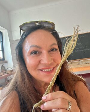 Norah Casey Instagram - As the temperature hit 25 degrees we headed up to the village of Sarnadas in the parish of Alte and a little weaving workshop, Casa do Esparto,  based  in the repurposed Escola Primária das Sarnadas. It’s one of a network of artisan spaces of the Loulé Criativo project which is revitalising ancient creative traditions in the region. There I met this wonderful woman Donna Aldegundes Gomes, born in the village, she proudly tells me she’s 89 years old and 60 years a weaver. She has a big heart, skilful hands and a wide smile. You can tell she loves what she does. Now she is passing on her knowledge to new generations and enthusiastic amateurs like me. She and the other women in the collective use Esparto grass which grows wild in this area - the Barrocal lands of the Algarve interior. Essential back in the day for carpets, rugs, baskets and much more, the women are bringing back the traditional method and weaving patterns to create lovely unique pieces, some decorative, many practical. I was in the baby class making key rings which was a lovely hands-on, gentle and calming experience. Hands touching hands, heads bent close together nudging the grasses into new shapes and patterns. #creativityinaction @loule_criativo @visitalgarve