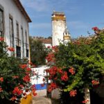 Patricia Heaton Instagram - On the way back to Lisbon from Nazaré we stopped in Óbidos, one of the most beautifully preserved villages I’ve ever visited. Beautiful cobbled streets lined with historic buildings drenched in flowers. Obidos Portugal