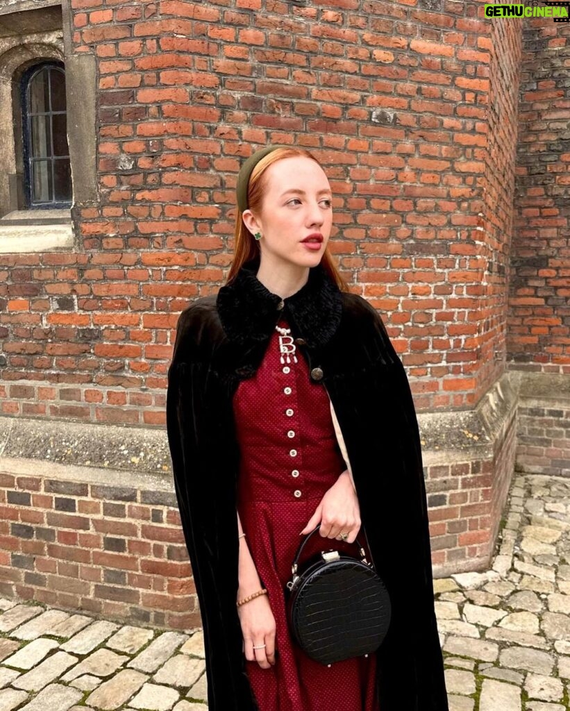 Rebecca Flint Instagram - if you can’t wear a cape in hampton court palace i’m not sure where you can 🌹? I have always wanted to see this incredible tudor palace for myself and I was so excited to have the chance! they had live cooking demonstrations inside the original kitchens, and we saw so many amazing tapestries and paintings… incredible day to visit! the puff headband trend always reminds me of the French Hood so I had to wear this army green one, along with this spectacular velvet and silk cape picked up from @classiccarbootsale in the spring! My dress is vintage from Japan, and my bag is @aspinaloflondon. The shoes are @empressaustralia 🔍 Not forgetting my B necklace as an homage to Anne 🅱❤ Hampton Court Palace
