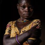 Ronan Donovan Instagram - A series of images from my latest article with National Geographic that published today, written by David Quammen (link in my bio). Photo 1: Teddy Atuhaire was a four-year-old in Mukichanga village, when a chimp entered the house while her mother was gone and carried Teddy away into a tree. The chimp gashed her head, broke her arm so badly it had to be amputated, and dropped her. The years of recovery have been difficult. With her parents dead, her siblings dead or gone, she lives by occasional labor and care from her aunts. Photo 2:  A wild chimpanzee, known as Max to researchers, lost both of his feet to poachers’ snares in two separate incidents. Some of the people living nearby set snares in the National Park to trap antelope, bush pigs, and other animals for food. Chimps, despite a taboo in Uganda against eating them, become unintended victims and are strong enough to tear themselves free. But the snare cable remains and cuts off blood-flow to the limbs. About a third of the chimps in one community in Kibale National Park have suffered snare injuries. Photo 3: An aerial photo depicts the area where both Teddy and Max live. One side is dominated by human agriculture and the other is what remains of Kibale National Park. The pressures put on the land by both humans and wildlife have created these unintended conflicts between humans and wild chimpanzees. I’ll continue to post images and stories from this longterm story that I began in 2011. Learn more @bulindichimps