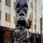 Sanford Biggers Instagram - 🌱Spring offerings ✨ Via @hammer_museum “Starting this weekend, the Hammer will have new exhibition spaces spanning an entire city block along Wilshire Boulevard--starting with Sanford Biggers’ @sanfordbiggers Oracle, inaugurating our outdoor sculpture pedestal at Wilshire and Glendon Avenue.  This 25 feet tall, 7+ ton bronze figure is part of Biggers's "Chimera" series, which combines the classic figures and movements of Greco-Roman sculpture with a variety of iconic African objects from the 14th to the 20th centuries.  For the next year, Oracle be seen every day by a wide range of people who walk or drive through one of the busiest corridors in the country.  Viewers are invited by the artist to leave an offering at the base of the sculpture. Starting this weekend, feel free to bring an offering of whatever speaks to your heart.  Oracle's presentation at the Hammer is supported by Marianne Boesky Gallery (@marianneboeskygallery) and is co-presented by the Hammer and Art Production Fund (@artproductionfund).  For more information on Biggers and Oracle, click the link in our bio. ___ 📸 Sanford Biggers, Oracle, 2021. Bronze. 282 5/8 x 84 1/8 x 122 1/8 in. (717.93 x 213.97 x 310.13 cm). Courtesy of the artist, Marianne Boesky Gallery, and Art Production Fund. Installation view, Sanford Biggers: Oracle, Hammer Museum, Los Angeles, March 26, 2023 – March 24, 2024. Photo: Joshua White.