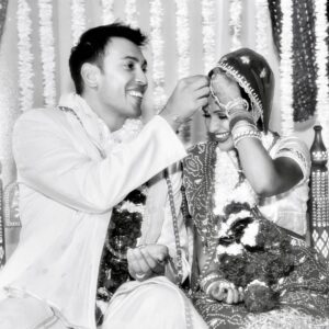 Sangita Patel Instagram - This photo was taken an hour before I said YES 💍 
I just got my Engineering degree the day before and then Sam whisked me away to Bahamas. Little did I know he had already met with my family and asked for their blessing 🥰 (my sisters kept a secret from me, how dare they 😂)

Sam got on one knee (same height as me when he kneels😊) I was complaining about the bugs on the beach and missed the whole ‘will you marry me’ I’m pretty sure I said Holy 💩 

20 YEARS! 
The moments, 
the memories, 
the ride….what 👏🏽 an 👏🏽 incredible 👏🏽 ride!

I think the best way to explain the carousel is K-I-S-S-I-N-G nursery rhyme, remember?!
First come love ❤️ 
then comes marriage 💍
Then came Ava and Shyla in a baby carriage 🍼
Oh and Indie 🐶 

Happy 20th Anniversary Sam (still checking you out, hubba hubba 😉❤️ 

#20thWeddingAnniversary #Myjoy #Mylife #laughter
