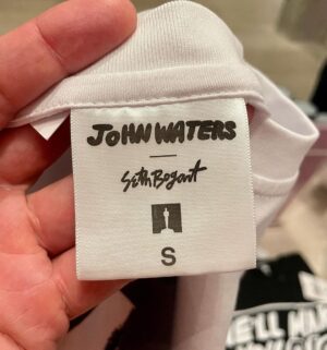 Seth Bogart Instagram - What an honor to design 3 collections of merchandise for the great new John Waters “Pope of Trash” show at @academymuseum ‼️
Seeing my art all huge on 2 walls at the end of the exhibit blew my mind. 

Love this pic @greggormanphoto took of John in front of my drawing of him. Just wait til you see the whole bathroom collection & the Divine/Pink Flamingos collection - both of those will be dropping sometime soon. Go see the show !!!