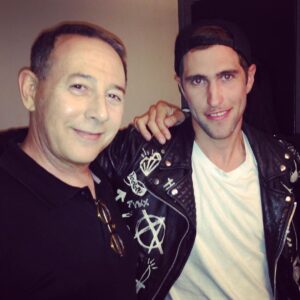 Seth Bogart Instagram - 10 years ago I went to see Elvira’s show at Knott’s Scary Farm. She did a spoof of one of my friends songs so we got to meet her after the show. Just before we headed backstage I got introduced to a man in a baseball hat. As I was shaking his hand I looked up into his eyes and he said, “I’m Paul.” HOLY SHIT ! It was Pee Wee. He walked backstage with us to see Elvira (his good friend obviously.) I guess he thought we were cool cuz he ended up walking around Knotts Berry Farm with us for a couple hours. We were escorted by a theme park professional and got to skip all the lines. Pee Wee didn’t do any rides or haunted houses, he would just wait at the exits for us- why I do not know!! All my friends commented that he had hot Big Top energy lol. Before he left he stopped us and pointed at a candy store and in a totally Pee Wee voice said, “I know how to get free candy!” And then we went into the candy shop and he asked to sample everything and bought nothing. My hero.