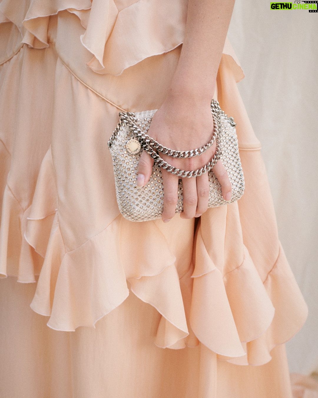 Stella McCartney Instagram - STELLA’S SUSTAINABLE MARKET: There’s a spirit of celebration this season. Our Stella woman is really living in the moment. She is free. x Stella Tiered and ruffled dresses feel vintage, brought into the now in modern materials and paired with #Falabella bags – crafted with lead-free crystal mesh on a recycled satin base. Entirely #vegan, the iconic chain is recycled brass and recyclable aluminium. Discover the full #StellaSummer24 runway collection at stellamccartney.com. #StellaMcCartney #ParisFashionWeek #PFW #crueltyfree