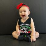 Tecia Torres Instagram - Mommy’s little model 🫶🏽 Having a daughter is everything I thought x1000. I’m so glad Alayah gets to be apart of our careers and experience moms doing what they love… another one of my pregnancy sewing creations … Raquel’s fight shirt turned into a baby onesie #RockNado #JourneyBacktoThrOcgagon #MomsCreations #Familia #MamasTwin