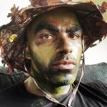 Toby Sandeman Instagram - Had a lot of fun in making Episode 3 Of The Game. A little #Bts commentary to go along with the Slides. ✨✨✨ When I first got sent the script I was going through my process of trying to identify ways to best illuminate what was on the page and the character, Garret Evans himself. And then, I had this Idea!!! Buttttt I knew immediately that if I wanted it to be used come filming time I needed people to FEEL the full effect on the table read which was only hours away from starting. (Showing is always better than telling) ✨✨ I dashed out the house. Hit the Google search and found the closest Army and Navy store. I bought camo face paints & an army fatigue boonie hat and messed around In the mirror until I showed up to the zoom table read ln FULL REGALIA, having NOT told a Soul I was doing so😝😝😝 (Actual footage of how I popped on screen In the table read in Slide 2.) The Roar of laughter was incredible!! Thankfully our Showrunner @devon_greggory, Execs, Writer and Director all loved it and gave the green light 🚦for Garret to wear not only the full face paint but the boonie hat too come time to film. (Slide 3 was the unasked for selfie I sent my showrunner after the table read) 🤣🤣🤣 Slide 4. Tim Moore (@makeupmagician31) our great make up artist saw the vision and went to town using his artistry to make it next level. Slide 5 Is the finished product. Slide 6, 7, 8- is Day one of filming with My Game Gang. Who really took it home playing off of Garrets Intensity, setting up the jokes or slamming them home amazingly. And finally our amazing Director @kelp1031 who really helped me bring my idea and fit it into her vision, guide me through the ep and yet have room to play!! It takes a Village!!!!