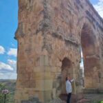 Valeria Britos Instagram - En la inmensidad del Arco Romano, único en España con tres arcadas. Medinaceli conocida como Ciudad del Cielo se encuentra en la provincia de Soria y es un pueblo con encanto. Calles empedradas, rincones que te transportan al pasado y paisajes que invitan a relajarse y conectatse con el presente. . . . . #medinaceli #soria #castillayleon #pueblosdeespaña #vomosviendo #pueblosconencanto #viajar #spain #travel
