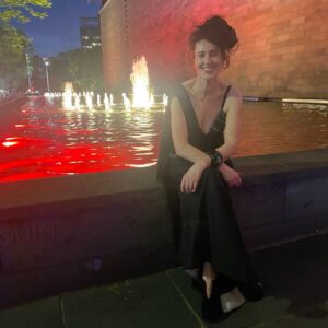 Virginia Trioli Instagram - The beautiful and very moving @ngv summer blockbuster @alexandermcqueen  Mind Mythos Muse uses our extraordinary collection to make sense of Lee’s voracious love of art, design, history, myths, literature, textiles and collaborators. So in that spirit I’m wearing a very special dress I bought in 2004 from the much-lamented Flinders Way.
Anne Valerie Hash @annevaleriehash is an haute couture designer who was a contemporary of Alexander McQueen and was also a star from the get-go. They were exhibited together in the very early days as emerging artists. Like Lee, Anne Valerie started by deconstructing mens suiting, finding a female form within strict, tailored lines. They both knew how to cut - properly, which is more rare than you’d think. I’m lucky enough to own a few McQueen pieces, including an astonishing boned and corseted black watermarked silk jacket. But this amazing dress is such a dream to wear and deserves to be out of the closet!
The headpiece is @neilgriggmillinery from 2005, of silk roses and antique 1920s lace , @lanvin cuff , @anyahindmarch clutch - all my own. It’s a really special show and a great tribute to the imagination and scholarship of @ngv staff, especially @berrydeluxe . Do go see it. A great night. @ngvmelbourne #ngvgala @visitmelbourne #fashion #design #annvaleriehash