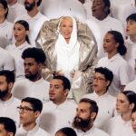 Xuxa Instagram - A gente sonhou, acreditou e conseguiu: o Natal da Reserva, Reversa, Mini e Go tem como estrela uma verdadeira lua - Xuxa. É, antes da nossa campanha de Natal pra você, um sonho realizado. A rainha se junta a Orquestra Maré do Amanhã (@orquestramaredoamanha) e ao Coral da Escola de Música da Rocinha (@escolademusicadarocinha) para uma apresentação de Lua de Cristal - nosso presente de Natal para clientes, parceiros, colaboradores, amigos e pro mundo. Um respiro de fé, magia e encantamento, quando todos somos um e juntos não existe mal nenhum. Neste Natal, a Xuxa te faz um convite: sonhe. Usereserva.com/xuxa Música: @michaelsullivanoficial #PraTodosVerem: O vídeo começa com uma cartela preta escrito “Natal Reserva: O Sonho Está no Ar” em branco. Em seguida, aparece uma nave espacial prateada com o pica-pau da Reserva centralizado. A porta da nave se abre e aparece a Xuxa. Ela é uma mulher branca, alta, magra, na faixa dos 60 anos com olhos azuis e cabelo loiro curto. Em seguida, aparece a Orquestra da Maré e o Coral da Rocinha. A Orquestra usa camisas sociais brancas da Reserva com uma capa prateada e segura os seus instrumentos musicais. O coral veste roupa branca com acessórios em prata. O vídeo finaliza com a nave aparecendo na tela e fechando a porta. Depois, entra uma cartela escrita “Este filme contou com a participação da Orquestra da Maré do Amanhã e do Coral Escola de Música da Rocinha. Obrigado por sonharem com a gente.”.