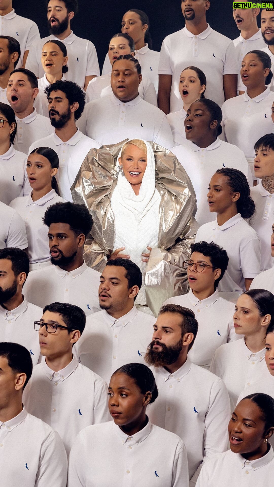 Xuxa Instagram - A gente sonhou, acreditou e conseguiu: o Natal da Reserva, Reversa, Mini e Go tem como estrela uma verdadeira lua - Xuxa. É, antes da nossa campanha de Natal pra você, um sonho realizado. A rainha se junta a Orquestra Maré do Amanhã (@orquestramaredoamanha) e ao Coral da Escola de Música da Rocinha (@escolademusicadarocinha) para uma apresentação de Lua de Cristal - nosso presente de Natal para clientes, parceiros, colaboradores, amigos e pro mundo. Um respiro de fé, magia e encantamento, quando todos somos um e juntos não existe mal nenhum. Neste Natal, a Xuxa te faz um convite: sonhe. Usereserva.com/xuxa Música: @michaelsullivanoficial #PraTodosVerem: O vídeo começa com uma cartela preta escrito “Natal Reserva: O Sonho Está no Ar” em branco. Em seguida, aparece uma nave espacial prateada com o pica-pau da Reserva centralizado. A porta da nave se abre e aparece a Xuxa. Ela é uma mulher branca, alta, magra, na faixa dos 60 anos com olhos azuis e cabelo loiro curto. Em seguida, aparece a Orquestra da Maré e o Coral da Rocinha. A Orquestra usa camisas sociais brancas da Reserva com uma capa prateada e segura os seus instrumentos musicais. O coral veste roupa branca com acessórios em prata. O vídeo finaliza com a nave aparecendo na tela e fechando a porta. Depois, entra uma cartela escrita “Este filme contou com a participação da Orquestra da Maré do Amanhã e do Coral Escola de Música da Rocinha. Obrigado por sonharem com a gente.”.