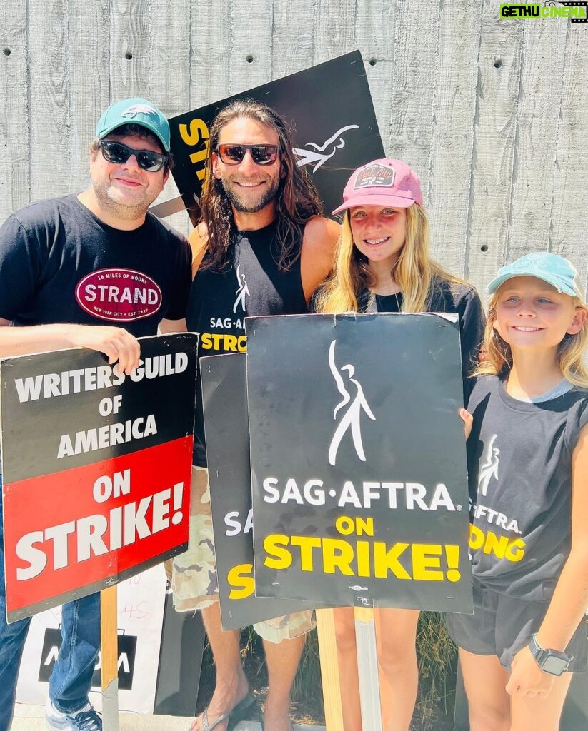 Zach McGowan Instagram - Went down to the studio to join the picket today. Saw some of the amazing writers of some of the awesome jobs I have had the pleasure of doing. Even managed to get some photos with some of them. If you are wondering if this strike is for real, I have not talked with a single writer or actor who isn’t in this for the long haul, however long it takes. FYI if you are on the side of the AMPTP you are wrong here. They are stealing from artist. End of story. I Brought my big girls today. Eventually I will bring the Ranger Crew, the Azgeda army, and all the Russian LMD’s. 🍻⚔️ #sagaftrastrong #wgastrong