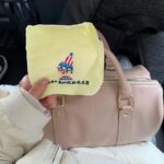 asmi Instagram - 新大阪駅で買ったリボンが可愛いくいだおれさん🎀とお気に入りのバッグ ハンカチって減っていくから