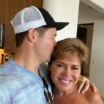 Adam Devine Instagram - It’s #WorldCancerDay! Join me in supporting #StandUpToCancer to help Kiss Cancer Goodbye! Share a kiss (preferably with no COVID) with a loved one (this is my mom on my wedding day) and post it using the #KissCancerGoodbye and tagging @SU2C. Then make your kiss count by donating at StandUpToCancer.org. This organization rocks and cancer is the worst. Donate if you can!