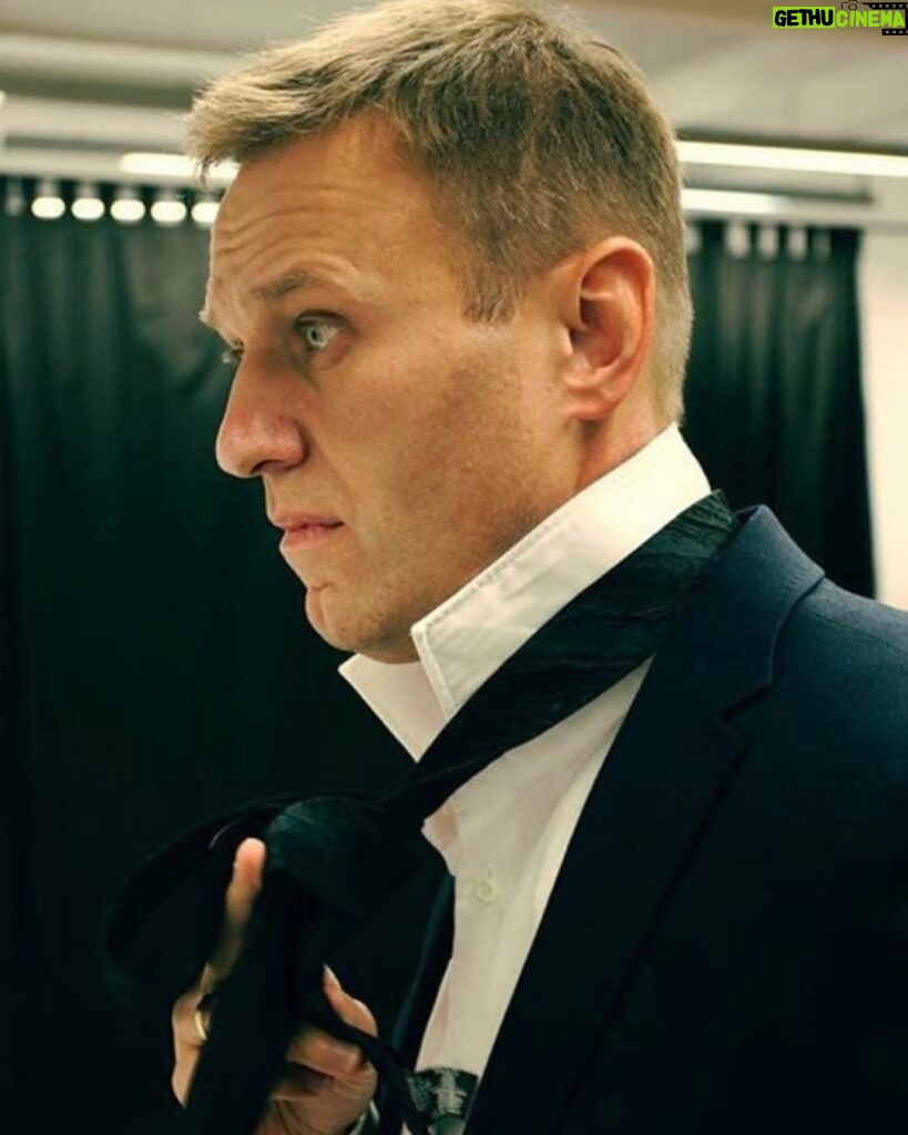 Alexey Navalny Instagram - Я смеюсь минимум три раза в день, даже когда совсем один в камере. Всё дело в музыке. Я начал из-за нее ругаться. В каждой камере стоит радиоточка. И с утра до вечера включены кошмарные радиостанции, где постоянно Газманов. Ну я и начал требовать, чтоб хотя бы на пару часов в день включали «Европу плюс». Когда я что-то требую, тюремщики — ясное дело — поступают ровно наоборот. Например, просил увеличить время, на которое мне дают ручку и бумагу (было 1,5 часа в день), — мне сделали 35 минут. И с музыкой так же вышло. После моей просьбы всему ШИЗО/ПКТ вообще вырубили музыкальные радиостанции и оставили только новостную — «Радио России». 24 часа вранья и рекламы лекарств. Но это еще не всё! Что сделает работник ФСИН, если захочет насолить с помощью музыки? Правильно! Включит классическую. Ведь он считает, что это пытки и наказание. И вот теперь во время завтрака, обеда и ужина в камерах играет классическая музыка. Я совсем не ценитель, но норм, могу послушать. Но только вот одно из проигрываемых произведений максимально мрачное и похоже на похоронный марш. А ещё, когда баландер даёт еду в камеру через кормушку в двери, он кладёт кусок хлеба на кружку, ну чтобы хлеб ни до чего не дотрагивался. Но выглядит это похожим на то, как на поминках кладут кусок хлеба на рюмку с водкой. А ещё тут часто дают какое-то подобие рисовой каши, что похоже на традиционное поминальное русское блюдо — кутью. И вот я сижу в камере за столом в своём чёрном зековском костюме, ем поминальную кутью, рядом кружка, накрытая хлебом, и играет похоронная музыка. В этот момент я представляю, что в Твиттер или Инстаграм идет прямая трансляция происходящего и вы видите всё это. Я не выдерживаю и начинаю смеяться. Самый весёлый человек на поминках 😉
