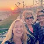 Angela Kinsey Instagram - Missing my sisters already! So thankful for these last ten days I got to spend with them. Billie, I’m so happy we got to go to @rogueptwellness with you and meet the awesome people who have become your online community this past year. Janet, I’m so glad we got to play tennis together! And my heart is so full that we got to play board games and ping pong with my kids and just sit and visit on the porch. And thanks to my husband, for listening to us talk about hummingbirds for 1/2 an hour one night and for feeding us all! 😂❤️ (And Billie and Janet, I know you are wondering of all the photos we took together why would I post this one but I just loved this moment. The wind had kicked up and was blowing our hair like crazy and I was trying to get this selfie before the sunset disappeared and we were cracking up and it just makes me so happy when I look at it. Love you both so much! 🥰)