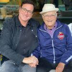 Bob Saget Instagram – HAPPY 99TH BIRTHDAY to the one and only @thenormanlear !!!
In this life, if you’re lucky,  if you have a handful of friends who mean so much to you. Norman Lear is of course an amazing human being in every way possible. Yes, he changed television forever with the smartest, most poignant and funniest shows ever seen— but everyone and everything he touches, he blesses with his clarity, brilliance, and love. And here he is touching ME! 
Norman, I treasure you as one of my dearest friends, and love you beyond words— and definitely beyond an Instagram post. Although this is a hell of a picture. 
Wishing you the happiest and healthiest of birthdays with your incredibly beautiful family. 
You are loved in the way I’m describing by so many people—Because you LOVE so many people. 
And to quote your beautiful proclamation, “I love you, and I don’t give a f*ck who knows it!”
Happy Ninety-Nine Years Dear Amazing Norman!! ❤️💙