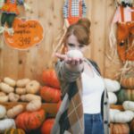 Bryce Dallas Howard Instagram - Hey, October 😉🍂⁣⁣ ⁣⁣ 📸: @andiejjane⁣⁣ ⁣⁣ [ID: BDH playfully poses in front of a display at @traderjoes with pumpkins of all different shapes, sizes, and colors. In full autumn vibes, she wears navy blue jeans, a white t-shirt, and a beige and brown cardigan. 3 smiling scarecrows hang on the wall in the back.]⁣